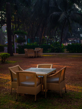 Wooden weave chairÂ and table in the lawn with sun light in the morning