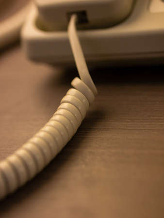 closeup of single curved spiral cable white wire. Phone line. Long distance connection. Technologies for staying in touch.の写真素材