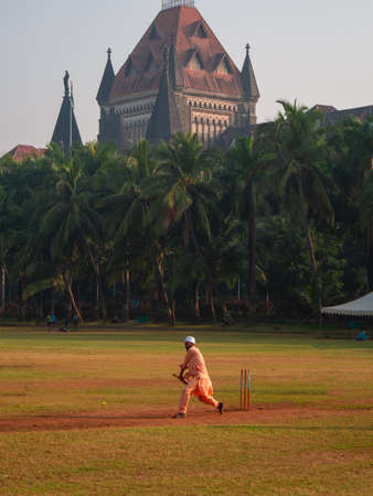 MUMBAI, INDIA - November 26, 2021 : Unidentified muslim man playing cricket with tennis ball at Oval ground next to Mumbai high courtのeditorial素材