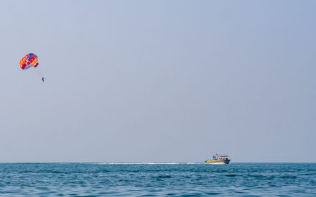 Sindhudurg, INDIA - December 23, 2021 : Unidentified tourist enjoying a parasailing ride at Tarkarli...
