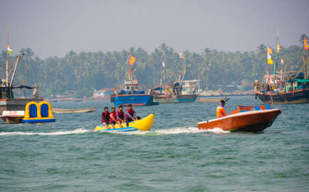 Malvan, INDIA - December 23, 2021 : Unidentified tourist enjoying a Banana ride at Tarkarli beach. The beach is famous for various water sports activities.のeditorial素材