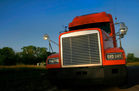 Orange semi truck wide angle shot with blue sky backgroundの写真素材