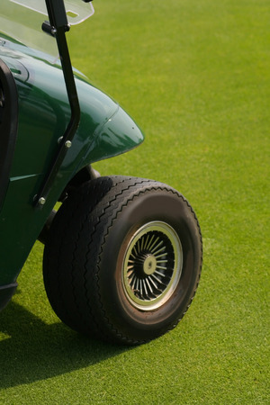 Front wheel of golf cart on lawnの写真素材