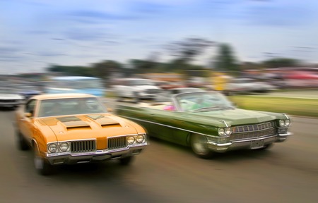 Orange and green color muscle cars cruising on historic woodward avenue.の写真素材