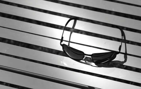 Sun glasses on beach chair concept in black and whiteの写真素材