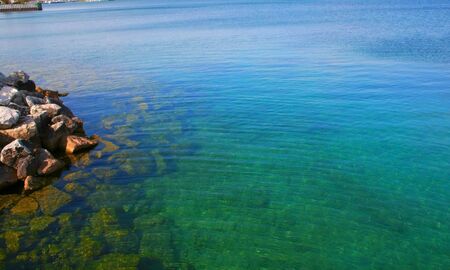Clear blue water lake Underneath stones are visibleの写真素材
