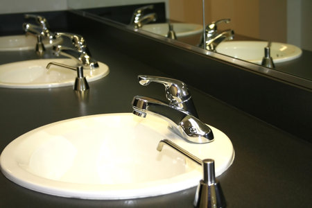 Drop of water falling from a shiny tap 