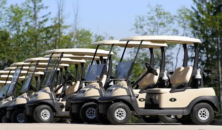 Golf carts parked side by side in a rowの写真素材