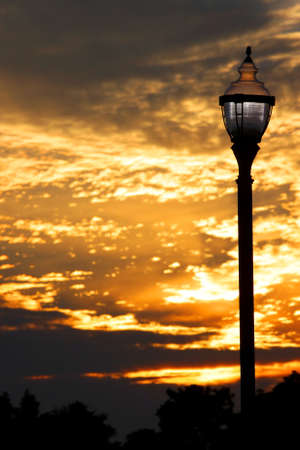 Old lamp post against cloudy evening skyの写真素材