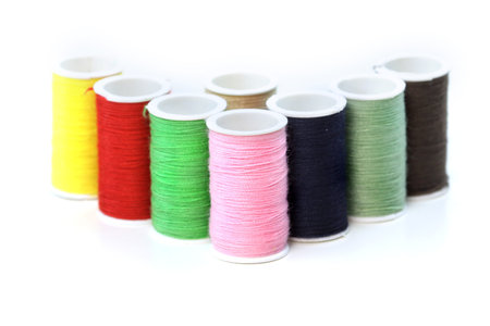 Many colorful bobbins isolated on white background 