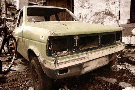 rustic car in junk yard in sepia color tone