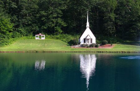 Scenic landscape with small old church by the lakeの写真素材