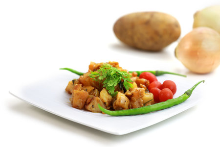 Delicious potato fry on plate with potatoes and onionsの写真素材