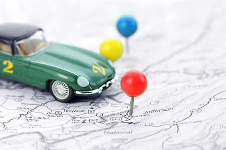 Dicast car and push pins on the map used as markers for destinationsの写真素材