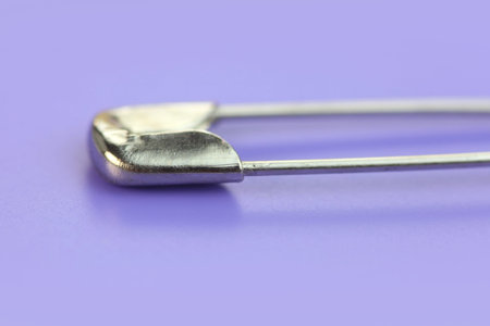 Extreme close up shot of a safety pin on purple background