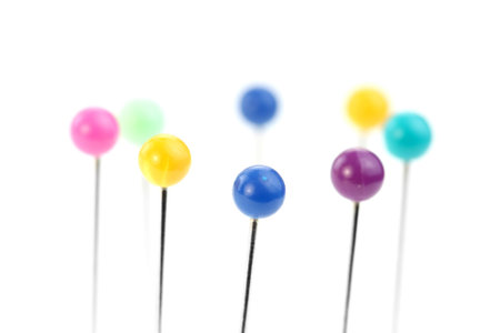 Colorful round headed pins on white background