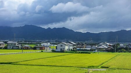 Rural landscape in Japan with rice fields and storm weatherの写真素材