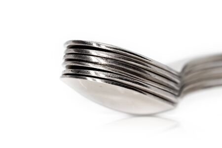 Stack of many spoons on white backgroundの写真素材