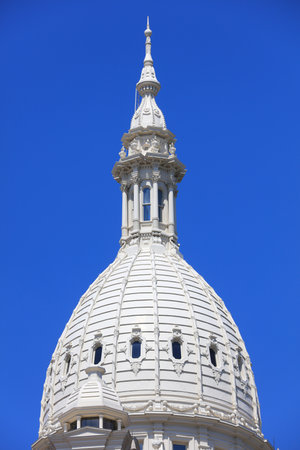 Elegant dome of Michigan state Capitol building in Lansing city against blue skyのeditorial素材