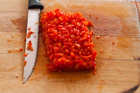 Cut red peppers on a cutting board with a knifeの写真素材