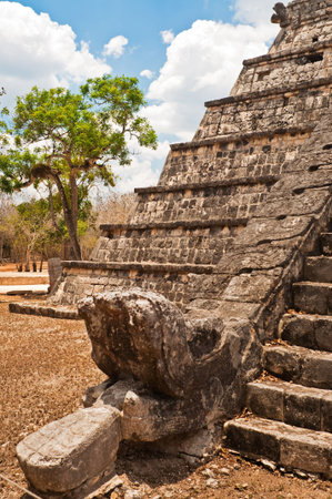 Feathered stone serpent at the foot of pyramid, Chichén Itzá, representing the head of Mayan god...
