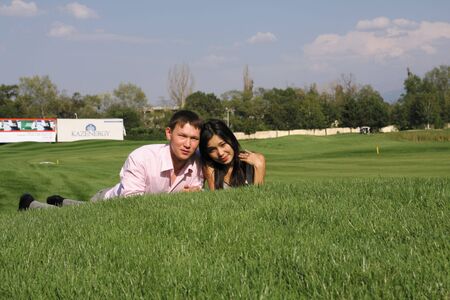 To fall in love, men and woman lying on green grassの写真素材