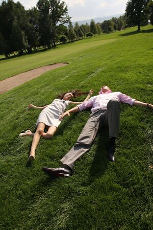 To fall in love, men and woman lying on green grassの写真素材