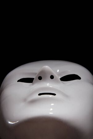 White mask on black background, man facesの写真素材