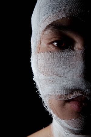 Obverse portrait of the young man which head is wound by bandageの写真素材