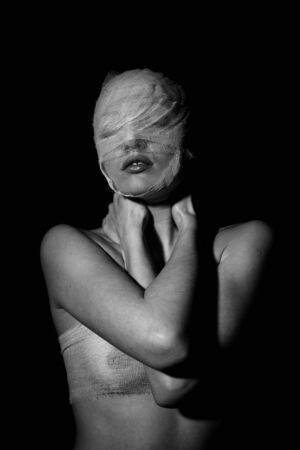The bared girl wound with bandage emotional portraits on a black backgroundの写真素材