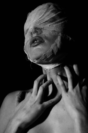 The bared girl wound with bandage emotional portraits on a black backgroundの写真素材