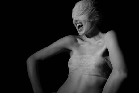 The bared girl wound with bandage emotional portraits on a black backgroundの写真素材