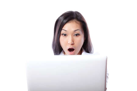 Protruding eyes of the young girl sitting at the laptopの写真素材