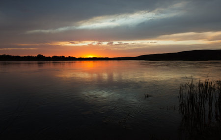 The river Ili decline, the sun behind horizon, clouds in the sky