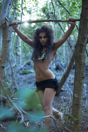 The beautiful girl amazon poses in jungle with a spearの写真素材