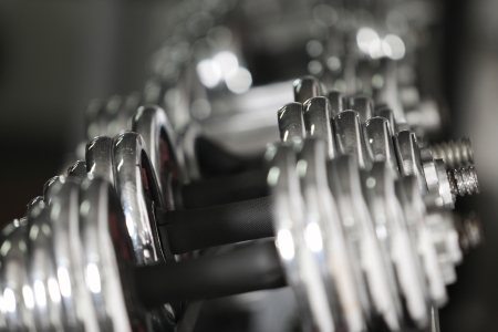 Dumbbells of different scales lie on the sports shelfの写真素材
