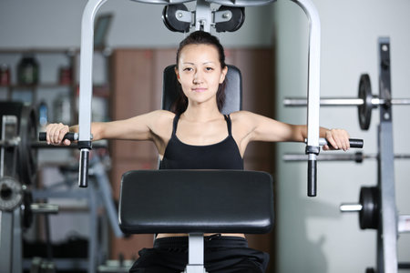 The girl is engaged in the gym doing exercise strengthens the chest