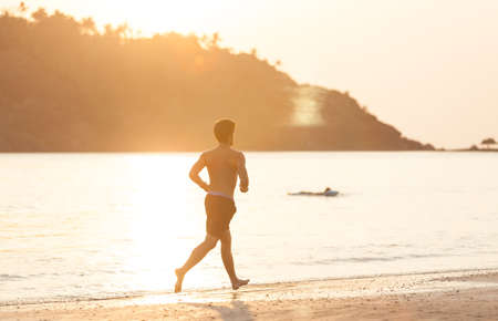 The guy the European runs on a beach against a declineの写真素材