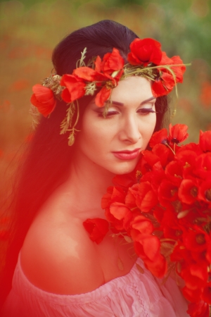 The girl with a bouquet of flowers on the field, wearing a wreath on her headの写真素材