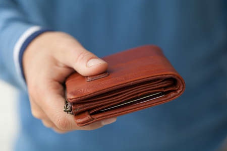 Closed brown purse in male handsの写真素材