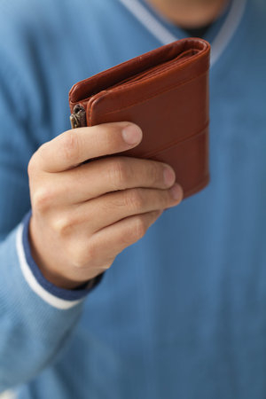 Closed brown purse in male hands