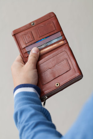 Open brown purse in male hands