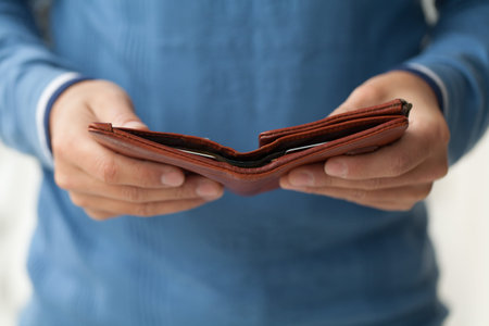 Open brown purse in male hands