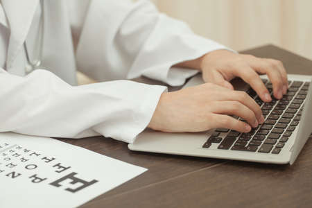 Doctor and modern technology, the doctor is working on laptop at the tableの写真素材