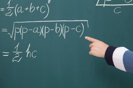 Trainee solve math problems written in chalk on the blackboardの写真素材