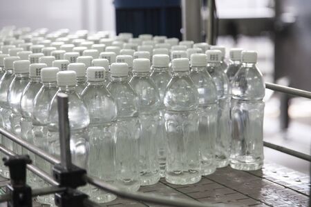 Bottle filled with water standing on the assembly lineの写真素材