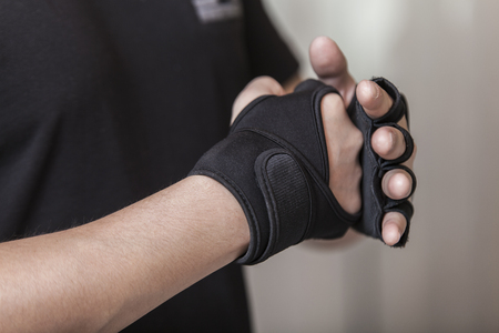 Man's hands put on sports gloves for a gymの写真素材