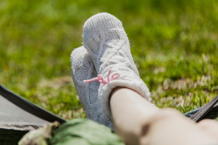 The girl on vacation, sits in tent having put out feet in warm socksの写真素材