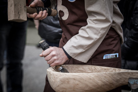 Man's hands of the joiner do a bowl, beats a hammer on a chiselの写真素材