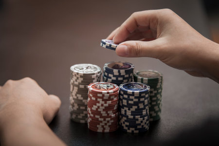 Man's hands pull to themselves a big heap of poker chips